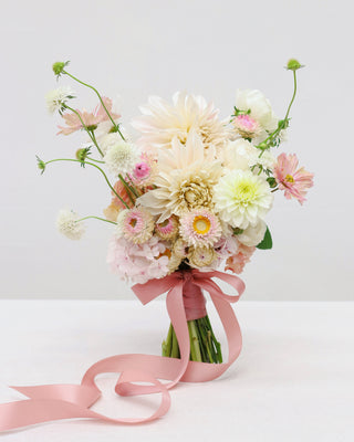 Bouquet of flowers with a pink ribbon on a white background