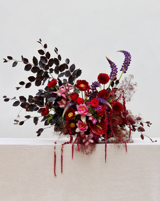 Colorful floral arrangement on a white surface with a light gray background